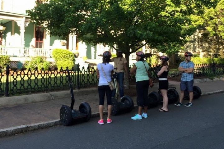 Guests enjoying the view of a huge white house in Charlotte from their Segway PTs