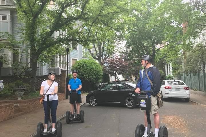 A guide leading two guests on Segways around Uptown Charlotte