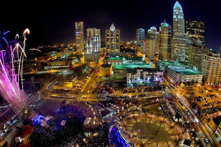 Charlotte, NC Skyline during the fourth of July. People are watching fireworks in the sky.