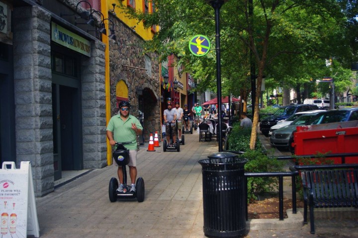 Line of segway riders riding down the city sidewalk