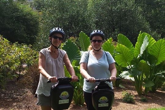 Two women smiling in a park in Charlotte NC. The skyline is in the background.